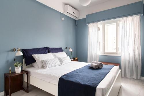 アテネにあるStylish Syntagma apartmentの青い壁のベッドルーム1室(大型ベッド1台付)