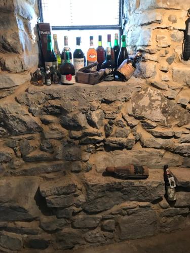a shelf with wine bottles on a stone wall at Bed & Breakfast Casa Marinella in Lenna