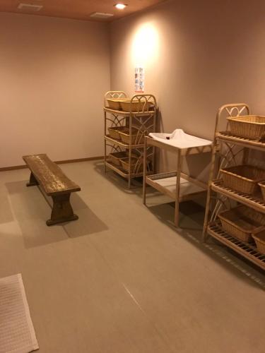 a room with a bench and baskets and shelves at Hotel Grand Terrace Chitose in Chitose