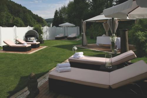 a backyard with couches and an umbrella and a grill at Hotel & SPA Waldecker Hof in Willingen