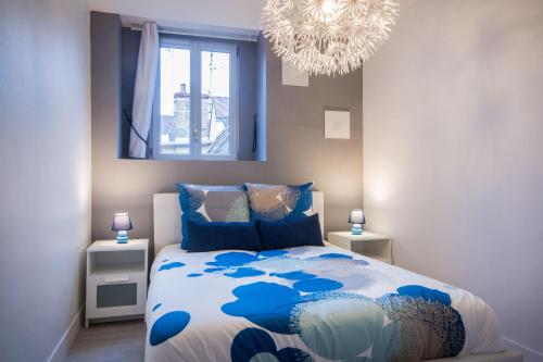 - une chambre avec un lit bleu et blanc et un lustre dans l'établissement SweetHome Dijon - Zola, à Dijon