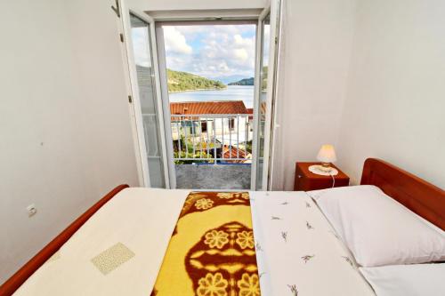 a bedroom with a bed and a view of the water at Apartments Nodilo in Polače