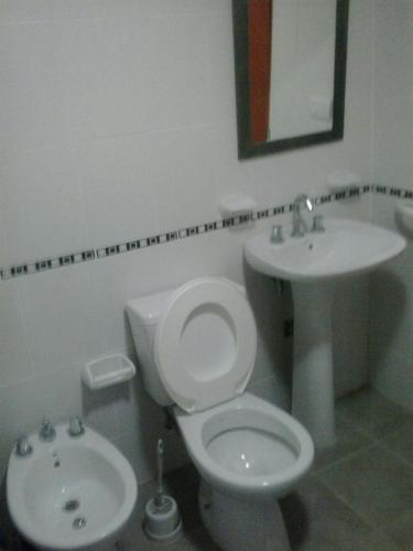 a bathroom with a white toilet and a sink at Apartamentos Atlantida in Colón