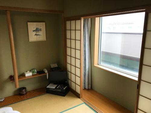a room with a window and a computer on a desk at Hotel Grand Terrace Chitose in Chitose