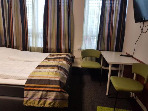 a hotel room with a bed and a desk and chairs at Hotel Wandsbek Hamburg in Hamburg
