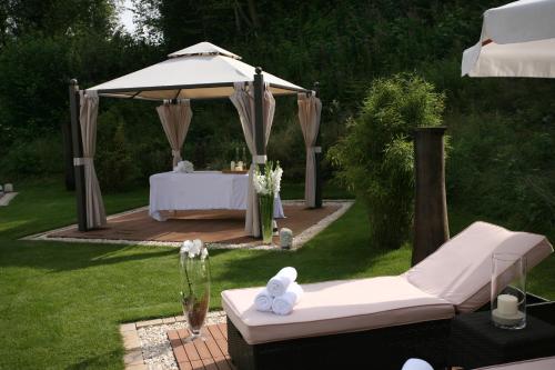 a gazebo with a table in a garden with a white tablestration at Hotel & SPA Waldecker Hof in Willingen