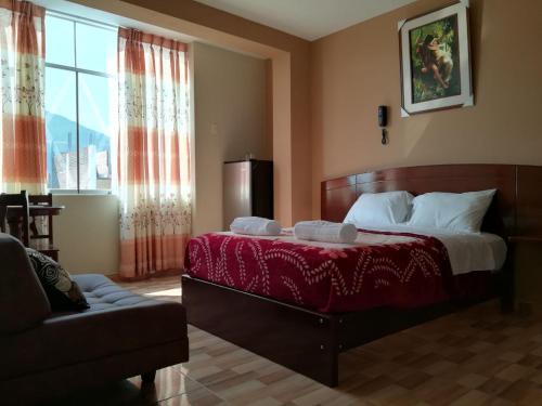 钦博特Hotel Real Chimbote的一间带床、沙发和窗户的卧室