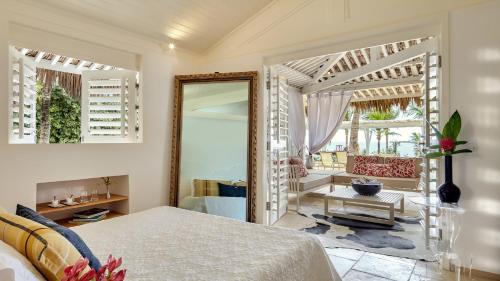 a bedroom with a bed and a mirror and a chair at The Chili Beach Private Resort in Jericoacoara