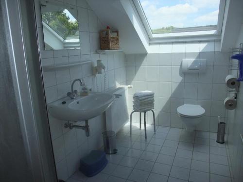 een badkamer met een wastafel, een toilet en een raam bij Dümpelhof Ferienwohnungen in Olsberg