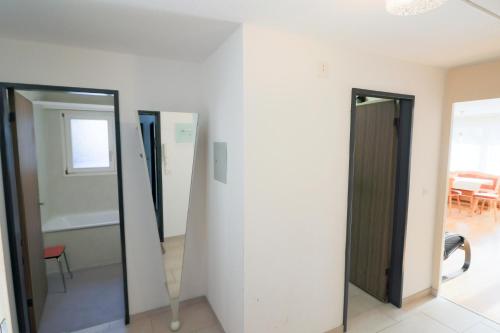 Zimmer mit 3 Türen und einem Spiegel in der Unterkunft Haus Bündabrücke - Mosbacher in Davos
