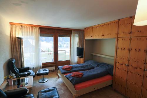 1 dormitorio con cama y ventana grande en Richmond - 302 & 405, en Davos