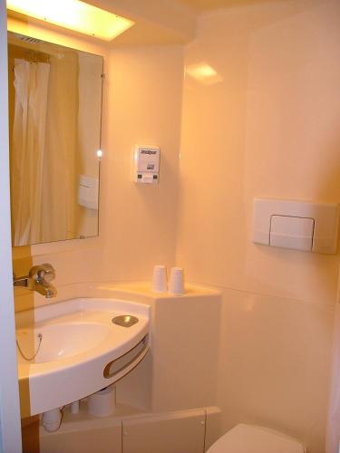 une salle de bain blanche avec un lavabo et des toilettes dans l'établissement Hôtel de la Place, à Germigny-des-Prés