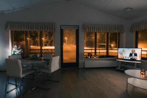 a living room with a table and chairs and a television at Guesthouse Brekka in Brekka