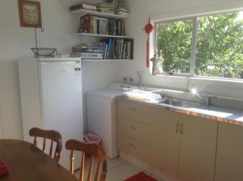 a kitchen with a sink and a table and a window at Noah's Boutique Accommodation Moeraki in Moeraki