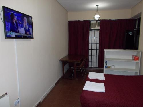a room with a bed and a tv on the wall at Apart Office in San Miguel de Tucumán
