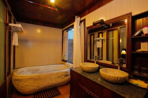 a bathroom with two sinks and a large tub at Hoi An Garden Villas in Hoi An