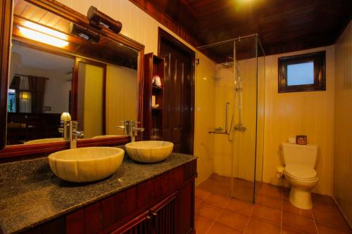 a bathroom with two sinks and a toilet at Hoi An Garden Villas in Hoi An