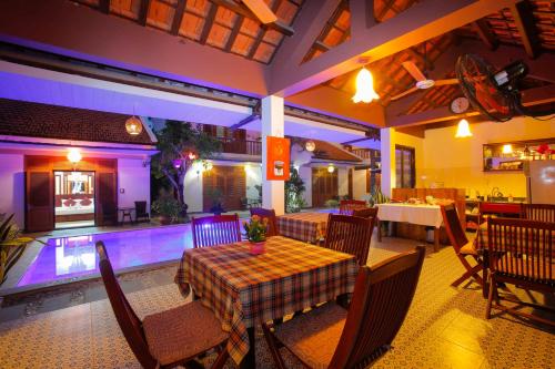 a dining room with a table and a swimming pool at Hoi An Garden Villas in Hoi An