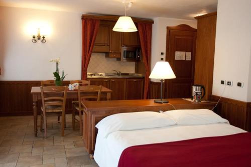 a bedroom with a bed and a table and a kitchen at Residence Le Grand Chalet in Courmayeur