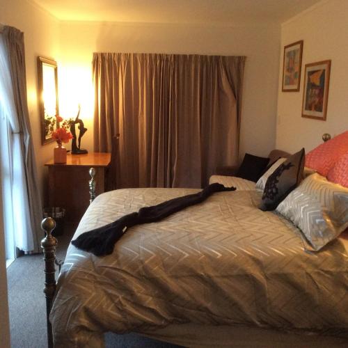 a bedroom with a bed with a blanket on it at Noah's Boutique Accommodation Moeraki in Moeraki