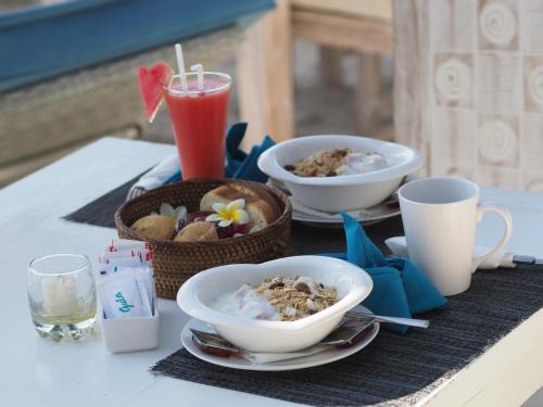 ein Tisch mit Schüsseln mit Essen und Getränken darauf in der Unterkunft Wah Danima Resort & Restaurant in Gili Trawangan