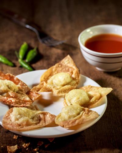 ein Teller mit Essen mit Wan Tans und einer Schüssel Suppe in der Unterkunft Banyualit Spa 'n Resort Lovina in Lovina