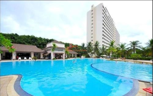 a large blue swimming pool with a tall building in the background at View Talay 1B Apartments in Pattaya South