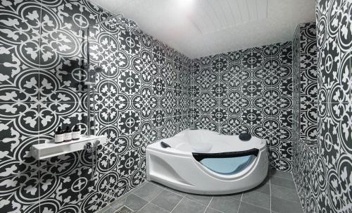 a bathroom with black and white wallpaper and a toilet at Hotel Nol in Gwangyang