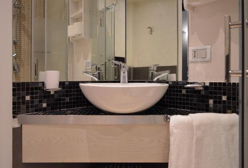 a bathroom with a white bowl sink and towels at Residence Piazza Garibaldi in Padova