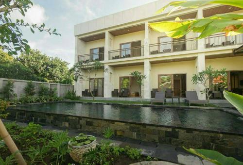an external view of a house with a swimming pool at Arnaya Homestay in Kuta