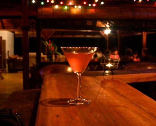 a drink in a glass sitting on top of a bar at Acajou Hotel in Grande Riviere