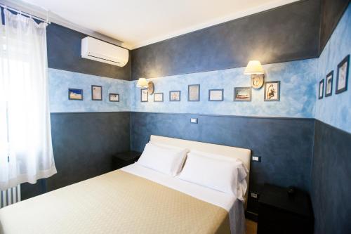 a bedroom with a bed and a blue wall at Hotel Diana in Ravenna