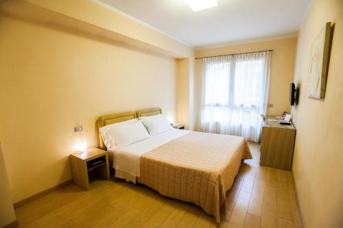 a hotel room with a bed and a window at Hotel Diana in Ravenna