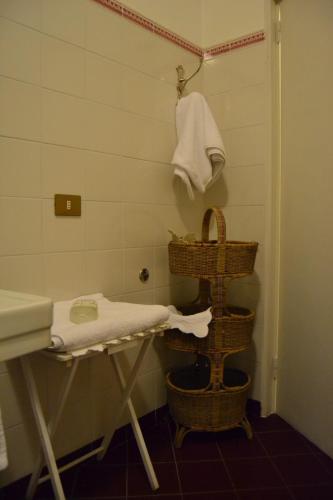 a bathroom with a sink and a towel rack and baskets at Albergo Residence Perosi in Tortona