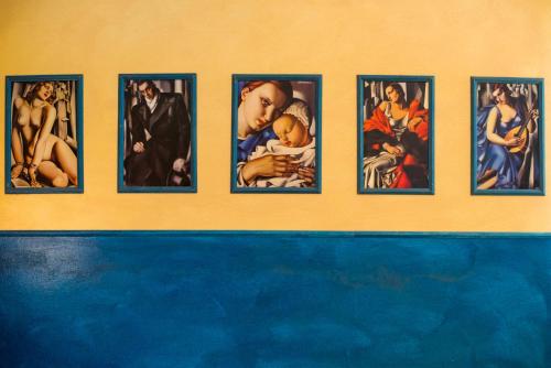 a wall with nine pictures of the icons on it at Hotel Diana in Ravenna