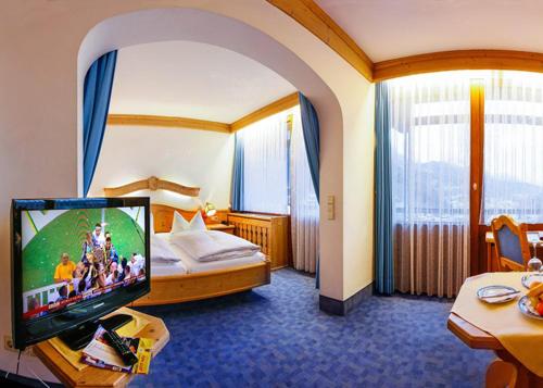 Habitación de hotel con cama y TV de pantalla plana. en Hotel Vier Jahreszeiten, en Berchtesgaden