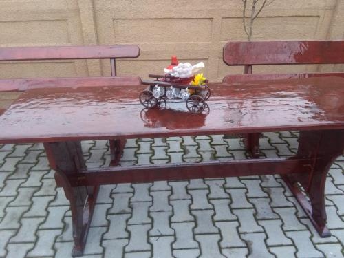 a red bench with a table in the rain at Casa Ovi și Simo in Haţeg