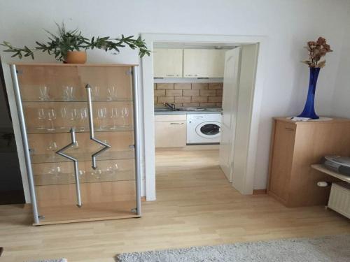 a kitchen with a door open to a room with a washer at Hotel Carlsruh in Braunlage