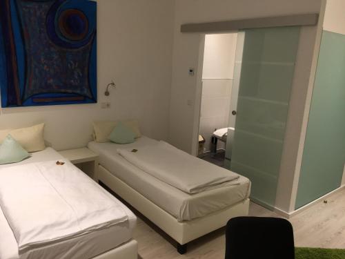 a room with two beds and a glass door at Hotel Barbarossa Karlsruhe Stadtmitte in Karlsruhe