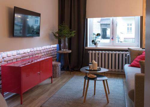 クリニツァ・ズドルイにあるGo2Krynica - Gawraのリビングルーム(赤いソファ、テーブル付)