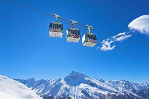 two ski lifts on a wire above a snow covered mountain at Eggerhof in Mallnitz