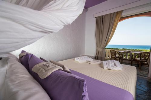 una camera con due letti e vista sull'oceano di Villa Georgia Apartments & Suites a Kalamaki