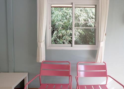 two chairs and a table and a window at Khao Yai Cottage in Mu Si