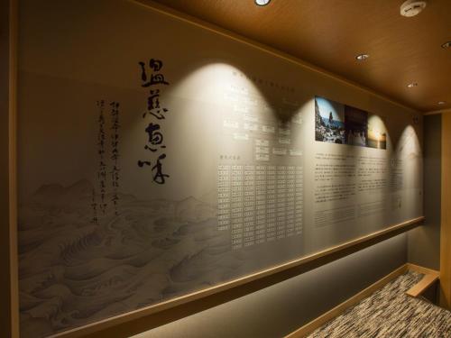 a display in a museum with a picture on the wall at Saka Hotel Kyoto in Kyoto
