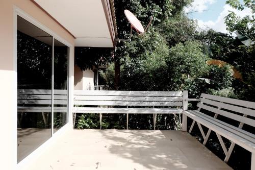 a white bench sitting on the side of a house at Khao Yai Cottage in Mu Si