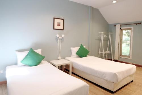 a room with two beds and a window at Khao Yai Cottage in Mu Si