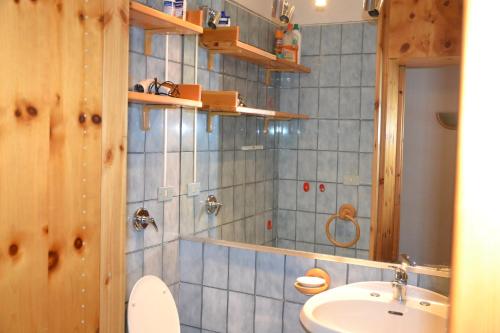 a bathroom with a sink and a toilet at Residence Edelweiss Ciel Blu in Pila