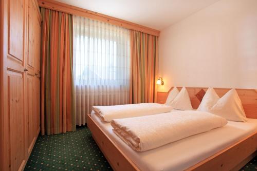 1 dormitorio con 1 cama grande frente a una ventana en Landhaus Bachler, en Brixen im Thale