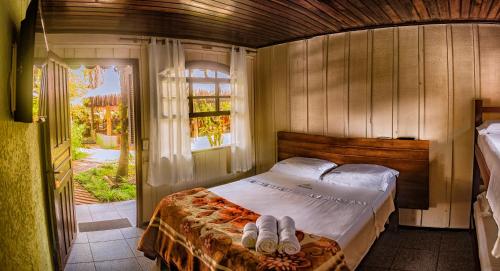 a bedroom with a bed with two towels on it at Pousada Marimar in Ilha do Mel