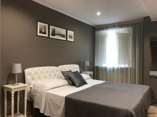 1 dormitorio con cama blanca y ventana en Di Martino Residence, en Roma